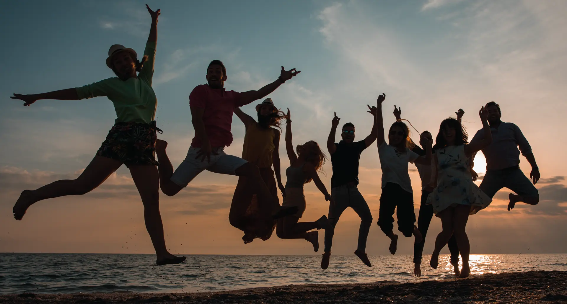 Silhouettes of a group of happy people jumping in the air on a beach during sunset, celebrating together. A red graphic overlay on the left reads: 'WHY EMPLOYEE RECOGNITION DRIVES ENGAGEMENT AND RETENTION #WORKPLACECULTURE'.